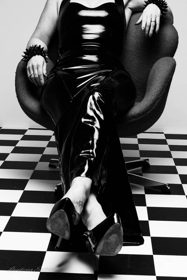 photographer Landicaa art fetish modelling photo. black latex dress lady sitting on red chair.